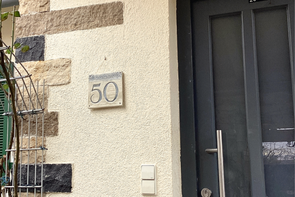 Hausnummer aus Keramik an der Hausfassade